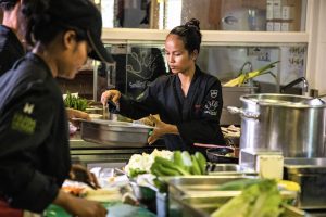 asiatische Frau kocht in einer Hotelküche