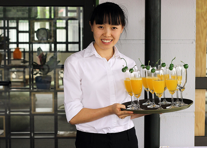 DER Touristik Foundation 10 Jahre KOTO Vietnam - Frau serviert Drinks
